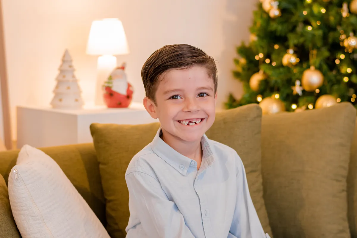 Menino sorrindo em ensaio de aniversário com decoração de Natal