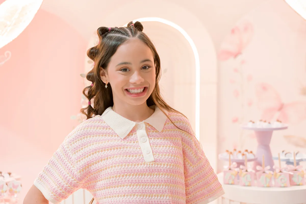 Menina sorrindo em festa de aniversário com decoração rosa em Londrina