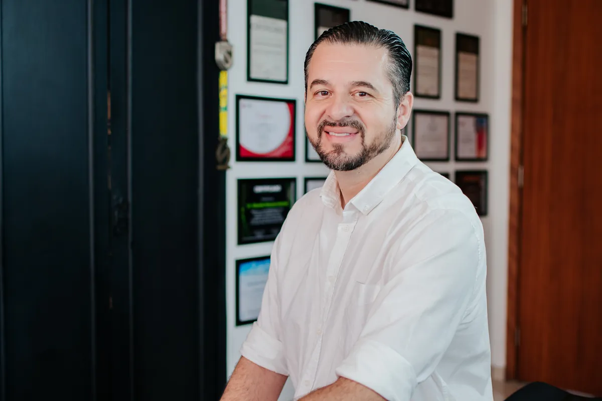 Retrato de empresário em escritório com certificados ao fundo em Londrina